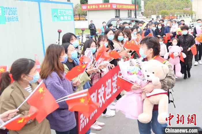 人们夹道欢迎白衣战士张杨。义乌市中心医院提供 去时千山雪归来万里春 浙江义乌援湖北白衣战士归乡